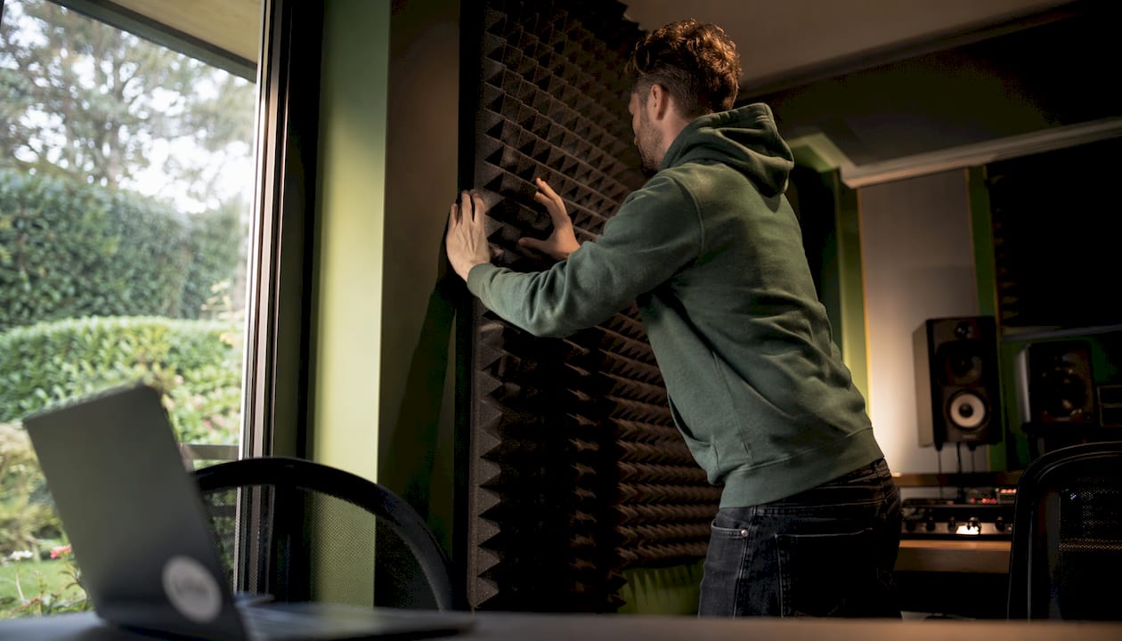 How Studio Foam Works: An Explanation for Audio Professionals 4 Een technicus stelt een geluidsisolatiepaneel van studioschuim af.
