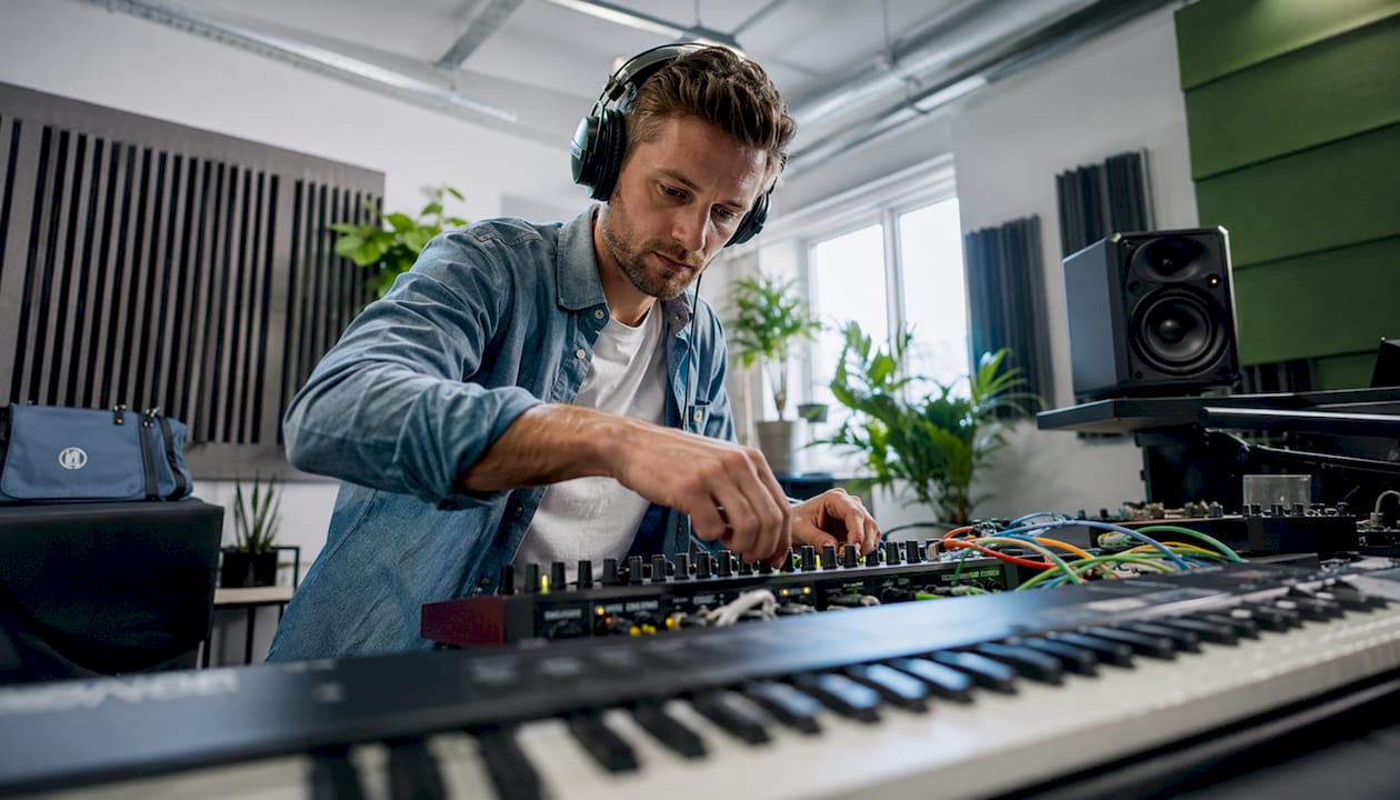 Een geluidstechnicus aan het werk achter zijn computerscherm in de studio.