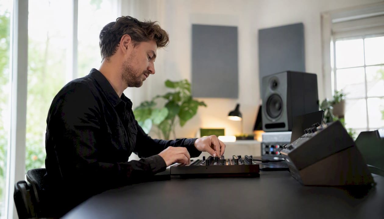 Bassgorilla.com Alternatives for Producers: Best DAWs and Plugins 5 Handen bedienen een MIDI-controller en een mengpaneel