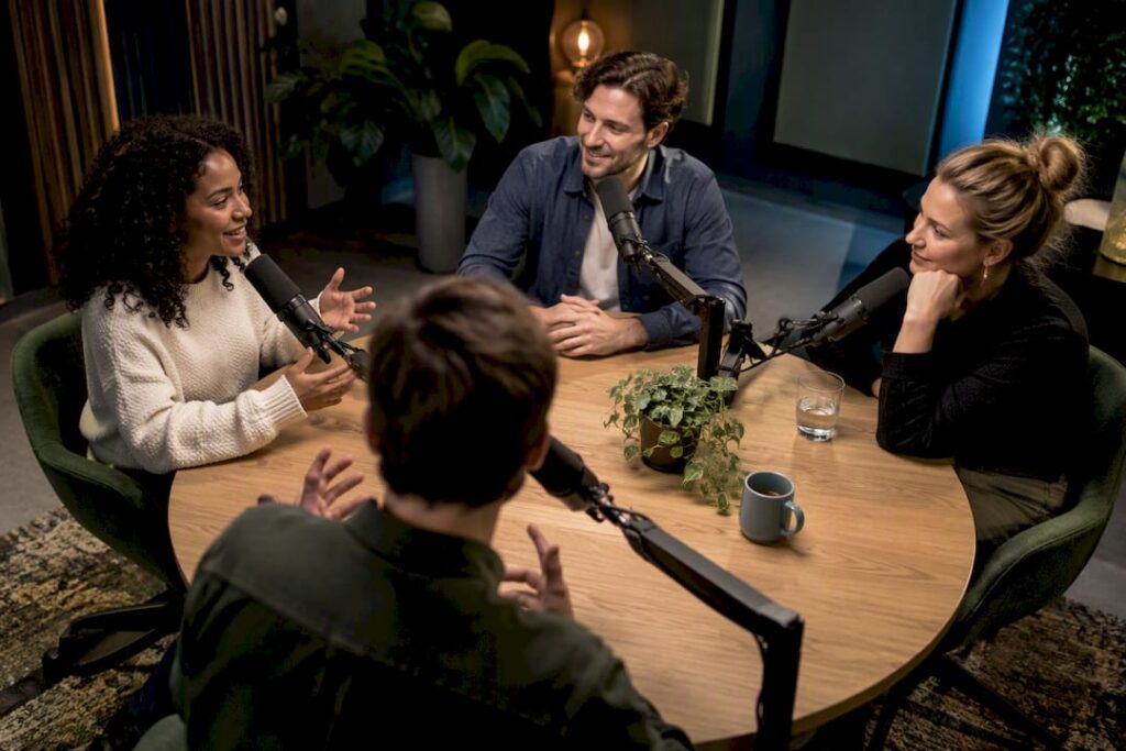 Four people in a professional podcast studio